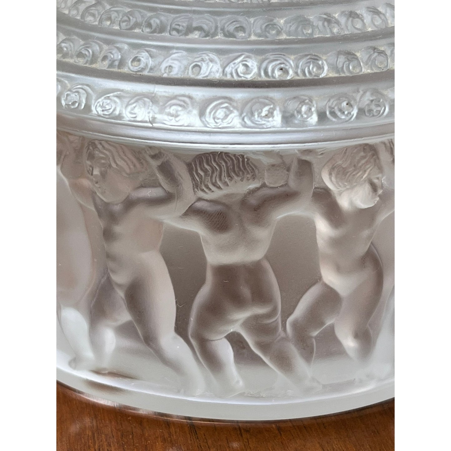 The Vintage Lalique Crystal Enfants Box by Lalique features frosted glass with nude cherubic children holding hands in a circle, intricate detailing, and a decorative border, showcasing the classic Enfants pattern with a translucent, textured finish.