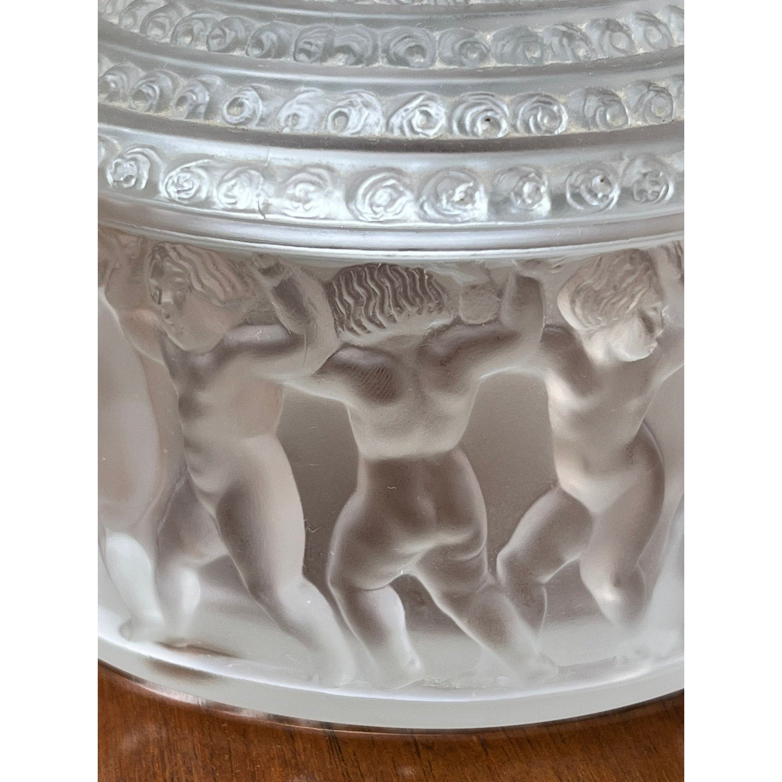The Vintage Lalique Crystal Enfants Box by Lalique features frosted glass with nude cherubic children holding hands in a circle, intricate detailing, and a decorative border, showcasing the classic Enfants pattern with a translucent, textured finish.