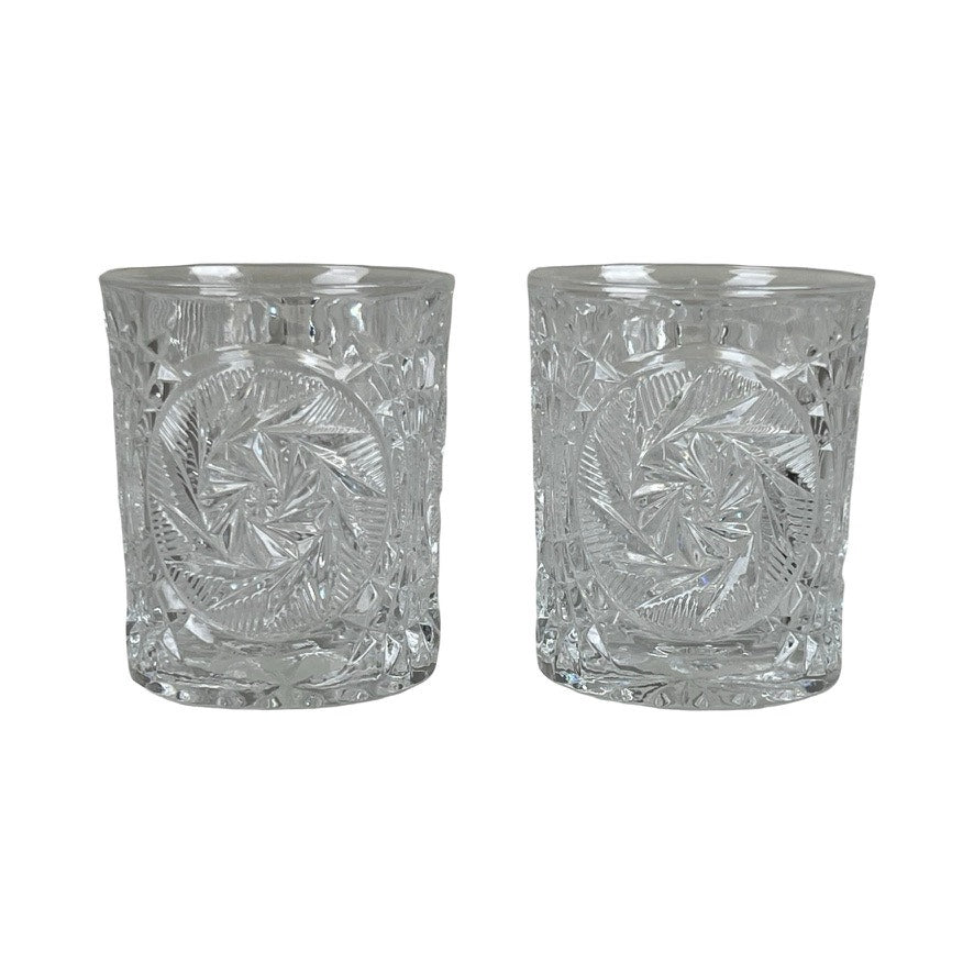 A pair of Fostoria Stowe Double Old Fashioned Tumbler Glasses sit side by side on a white background, showcasing their intricate geometric patterns and vintage American glassware charm.