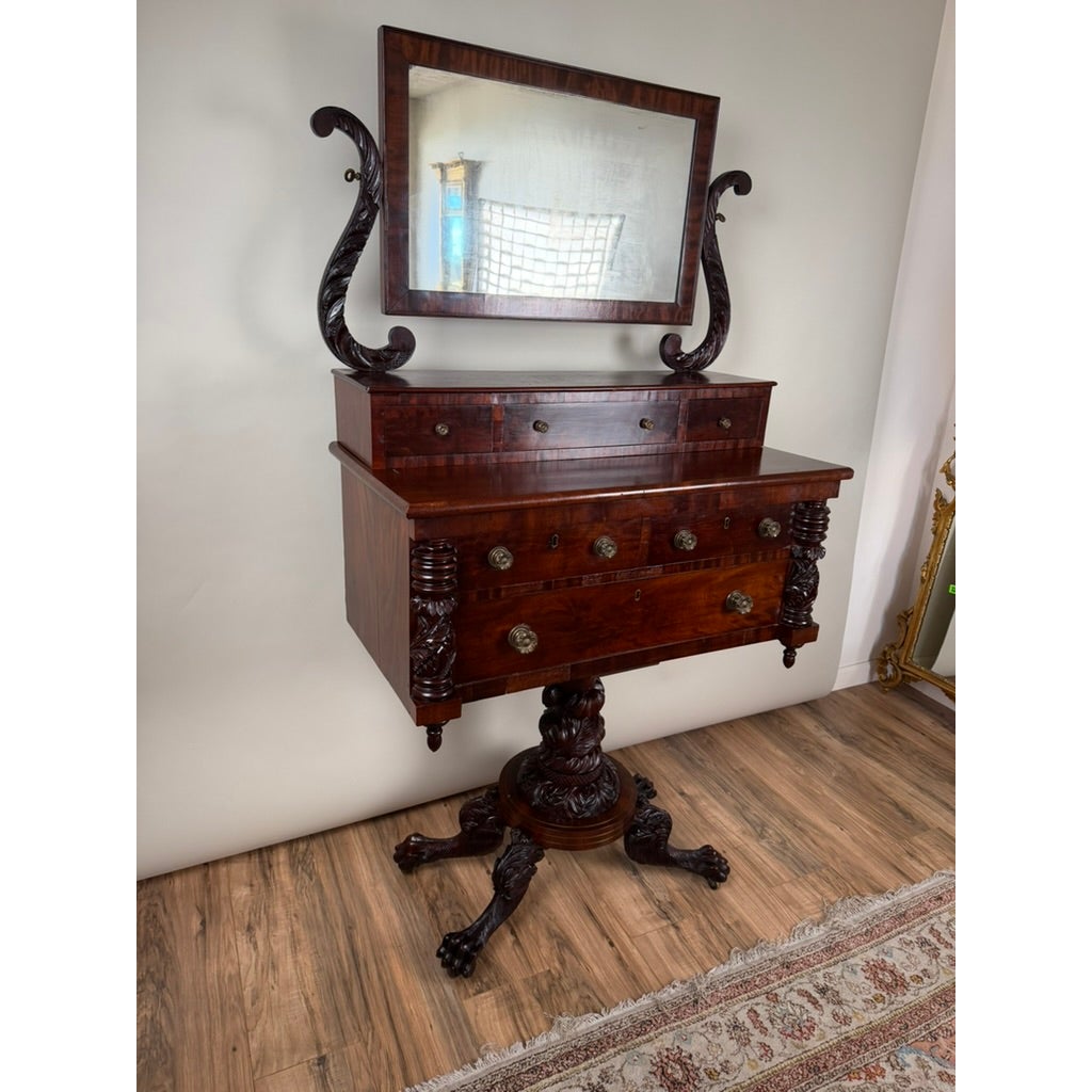 American Classical Carved Mahogany Dressing Table with Original Mirror, Probably New York, c. 1825–1835, featuring a central pedestal base, carved claw feet, and an adjustable rectangular mirror supported by scroll-shaped arms.
