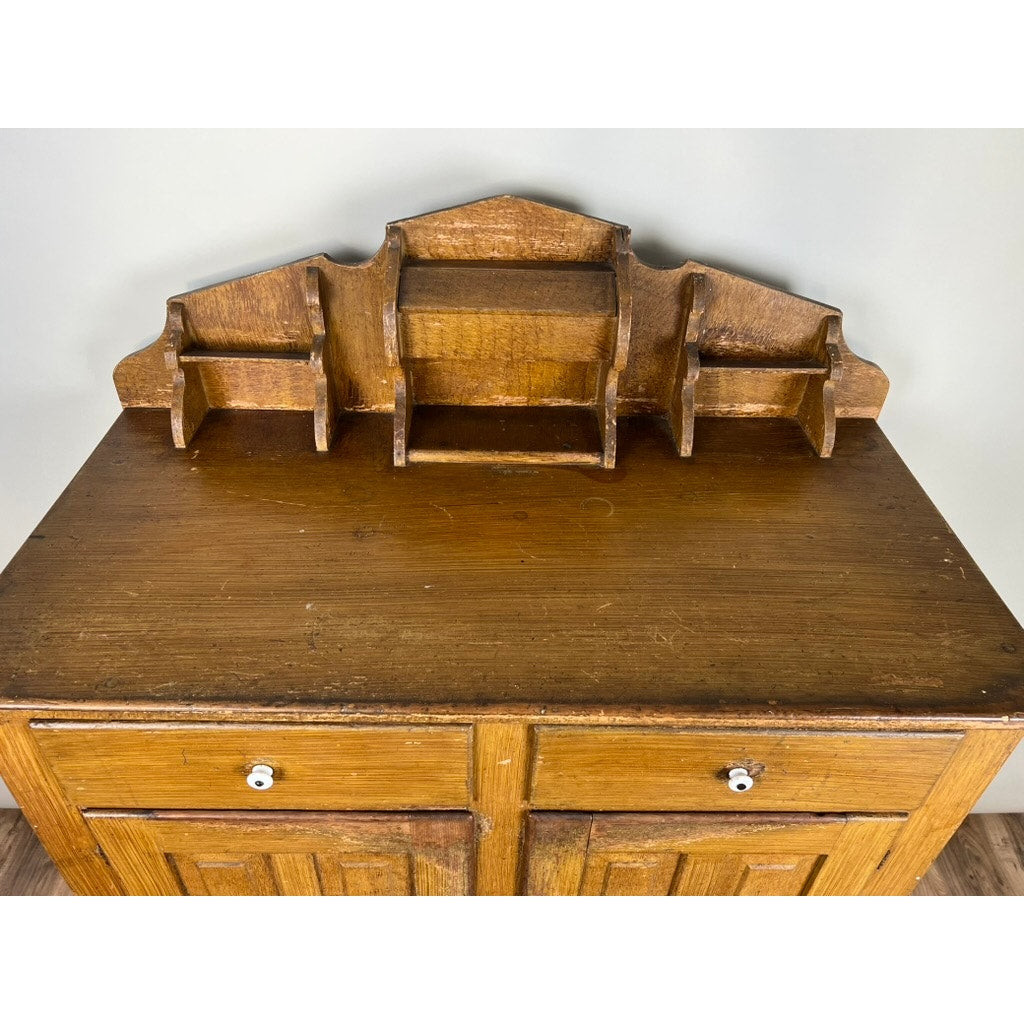 An Antique Victorian Country Grain Painted Jelly Cupboard c. 1870 with a rustic, worn finish features two drawers and is topped by a coordinating wooden organizer with multiple compartments.