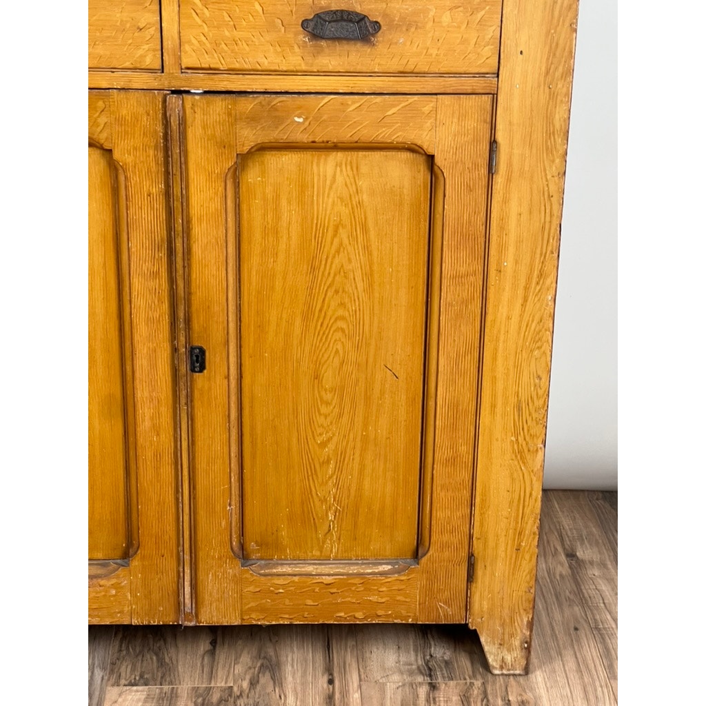 A close-up of the Antique Victorian Grain Painted Country Jelly Cupboard c. 1870 shows its rectangular door and upper drawer with metal handles, light brown grain-painted wood, and classic country charm, standing elegantly on a wooden floor.