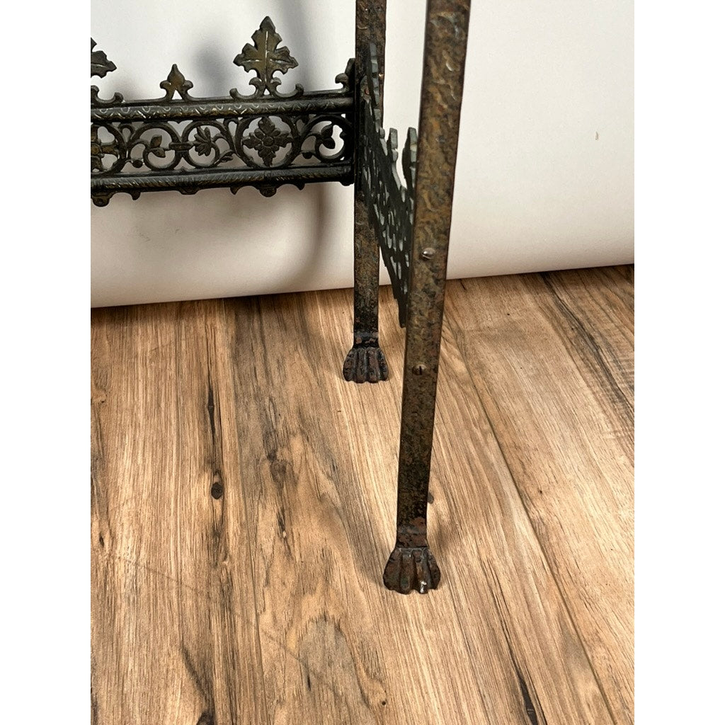 The Antique Gothic Revival Cast Iron and Brass Phone Stand, attributed to Oscar Bach or Bertram Segar (c. 1920 Greenwich Village), features ornate paw-footed legs and intricate ironwork, shown here standing on a wooden floor with a white background.