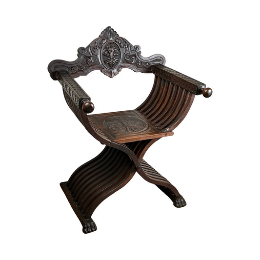 Antique Italian Renaissance Walnut Savonarola Chair, late 19th century, with curved X-shaped legs, carved armrests, and an elaborate fleur-de-lis backrest. Features ornate detailing typical of Renaissance Revival design. Brand unknown.
