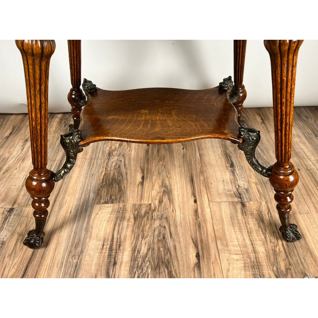 A close-up of the Antique Victorian Oak Lamp Stand with bronze lions head mountings (late 19th century), highlighting its ornate carved legs and decorative details, reminiscent of classic Victorian interiors. Brand: None/Unknown.