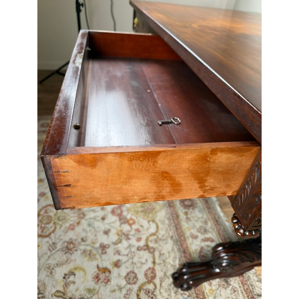 Open drawer of a New York Classical Revival Carved Mahogany Double-Pedestal Library Table, labeled Ernest F. Hagen, containing a small key.