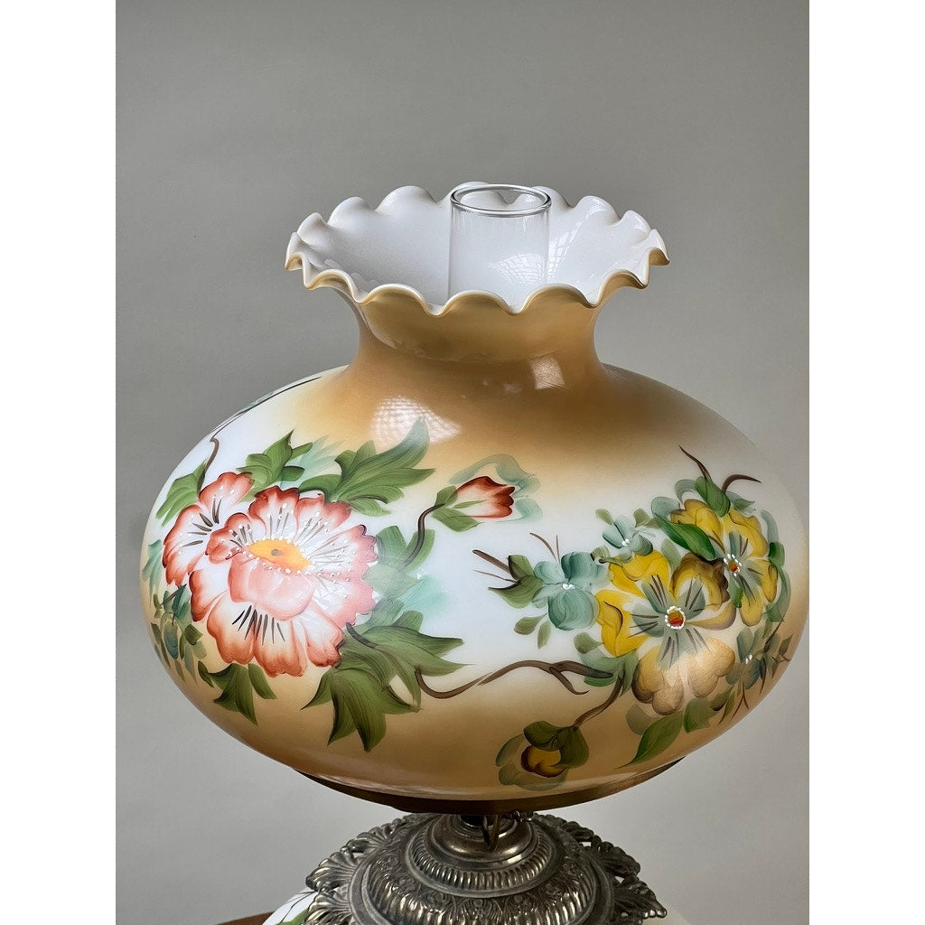 The Vintage Hand-Painted Floral Milk Glass Hurricane Parlor Lamp features a ruffled glass shade with pink, yellow, and green florals on an ornate silver base, brand unknown, set against a neutral background.