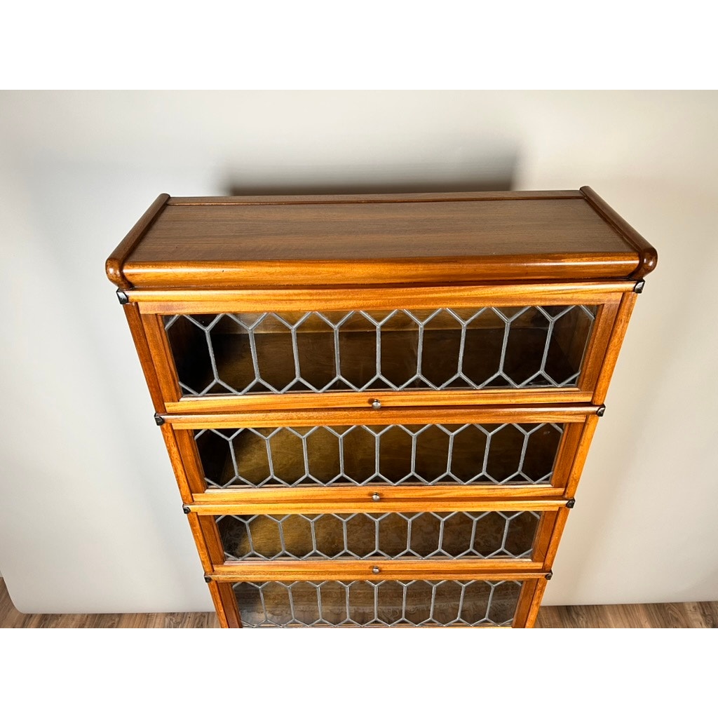 A top-down view of a Vintage Globe Wernicke Leaded Glass Five Stack Barrister Bookcase with decorative diamond-patterned glass doors by Globe Wernicke, shown on a wooden floor against a light-colored wall.