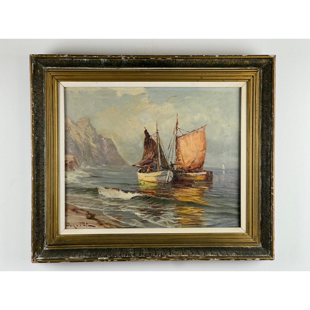 “Two Ships Off the Beach” is a signed oil on canvas painting depicting two sailboats near rocky cliffs, with sunlight on the water and soft clouds above, set in a textured gold and brown wooden frame. Brand: Unknown.