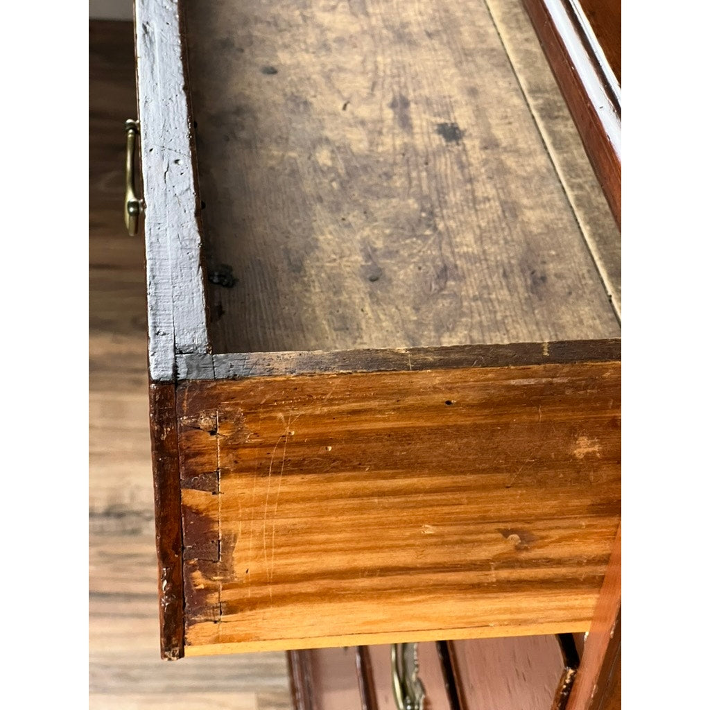 A close-up of an open, empty drawer from the Antique Chippendale Pine Graduated Four Drawer Chest (late 18th c., attr. Northampton MA) shows scratches, wear, and wood grain that highlight its rustic vintage condition, with partial views of the floor and drawer handles.
