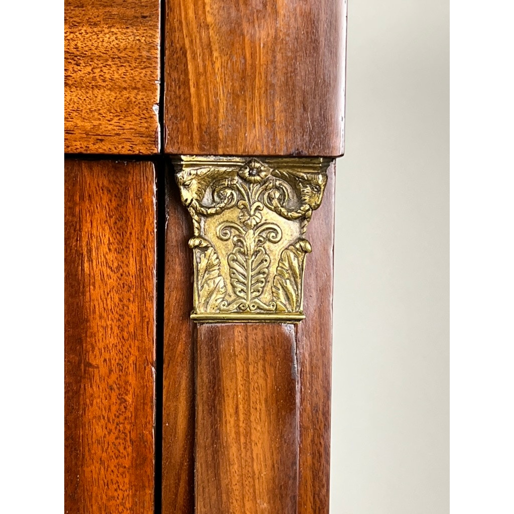 Close-up of an Antique French Empire Secrétaire Abattant with mid-19th century ormolu mounts—decorative brass accents with leaf and scroll motifs—set on a mahogany veneer. Brand: Unknown.