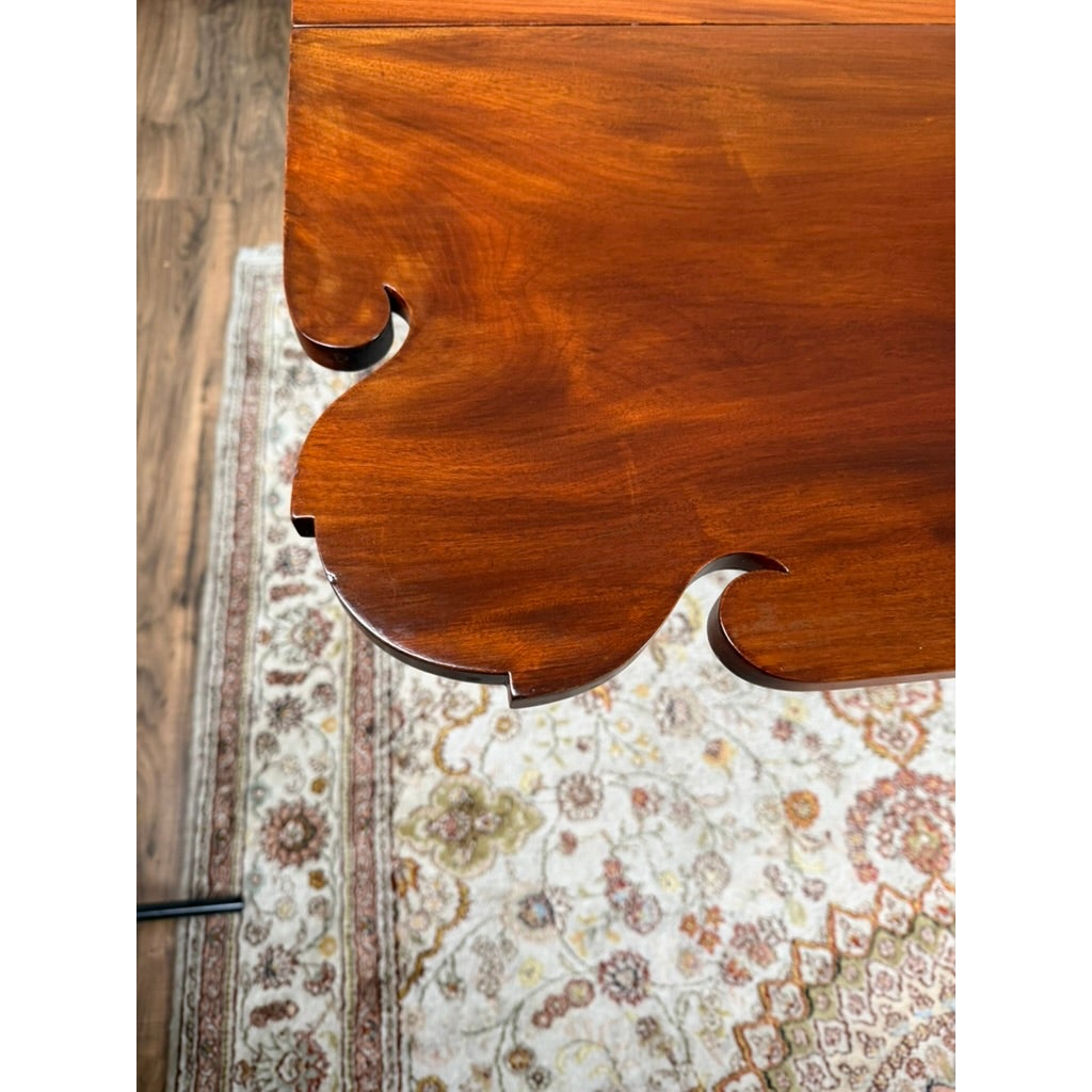 Close-up of the corner of an American Classical Carved Mahogany Drop-Leaf Breakfast Table, c. 1825–1840 Possibly New York or Philadelphia, featuring ornate, scalloped edge carvings.