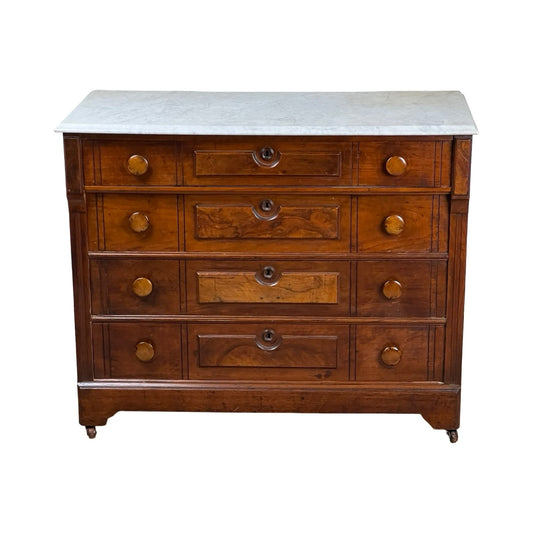 An Antique Victorian Marble Top Four Drawer Chest c. 1910 featuring a white marble top, round brass knobs, and small caster wheels—a charming vintage piece. Brand: Unknown.