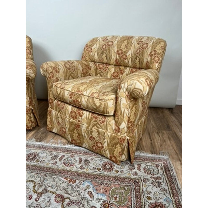 Rolled arm club chairs in warm patterned fabric with tailored skirts