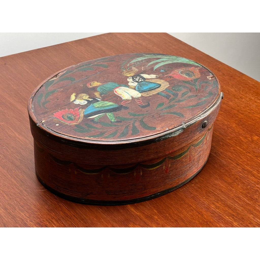 An antique German polychrome painted bentwood "Spanschachtel" ribbon box (late 18th century) featuring a hand-painted floral design and two seated figures in traditional clothing—an exquisite piece of European folk art.