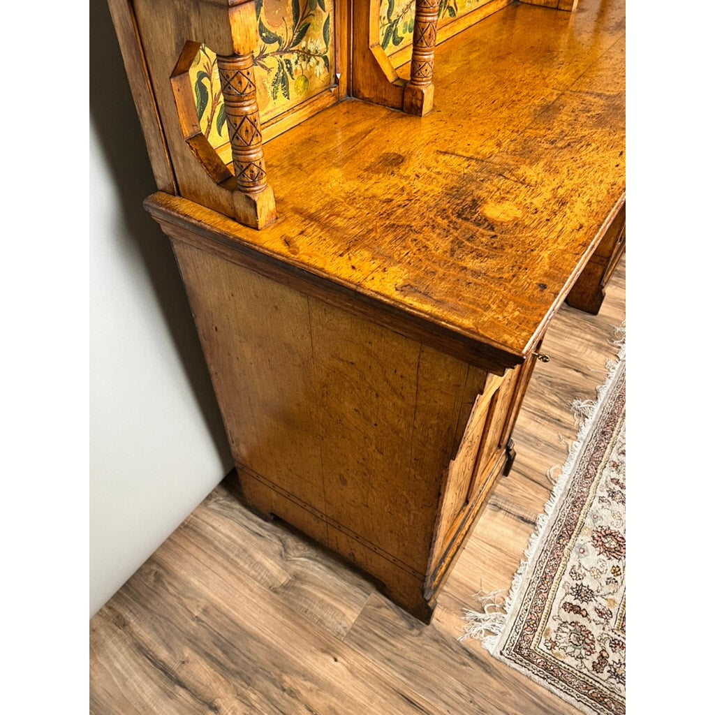 A close-up of an Antique Victorian Aesthetic Movement Oak Desk in its original late 19th-century finish, featuring ornate columns and a yellow floral back panel, placed on a wooden floor beside a patterned rug.