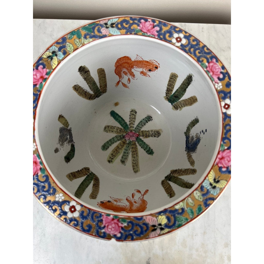 The Vintage Chinese Famille Rose Fish Bowl, signed Minicucci, features hand-painted floral rims, animal illustrations like squirrels and a bird, plus green and brown foliage inside. Displayed here on a marble surface. Brand unknown.