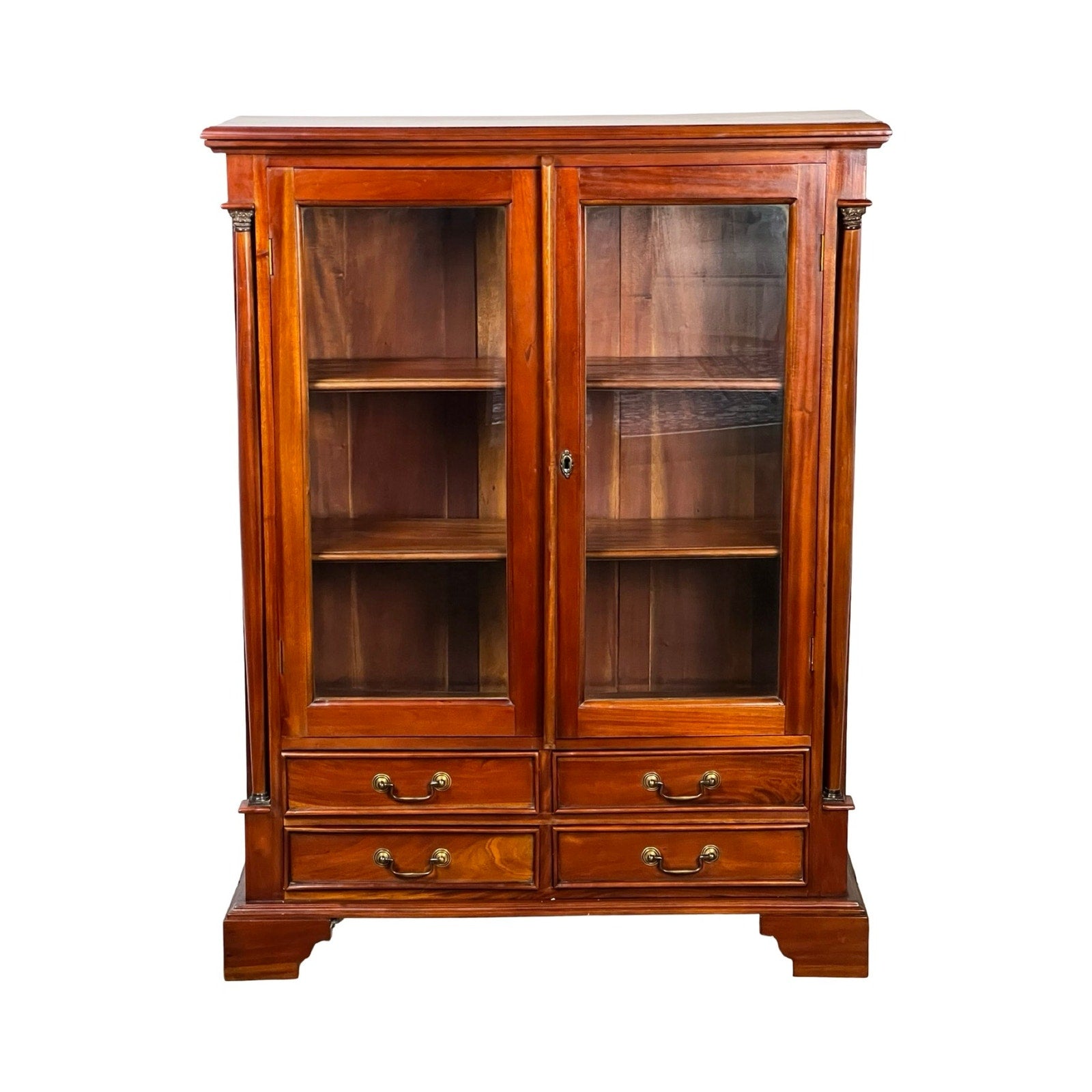 The Vintage Victorian Style Glass Door Mahogany Bookcase features two glass doors, three interior shelves, and four bottom drawers with metal handles and a polished finish. Brand: None and/or Unknown.