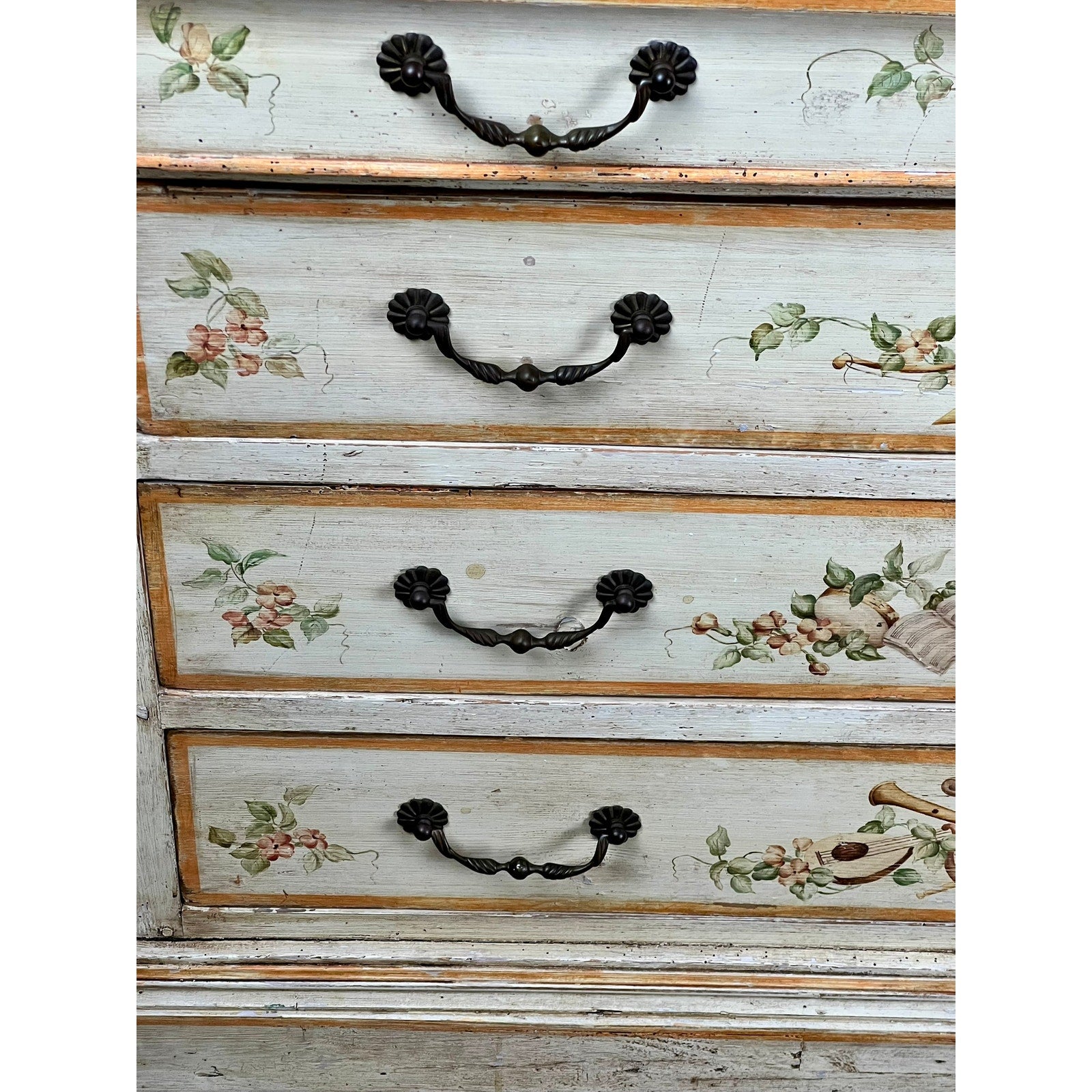 Close-up of three drawers on the Antique Italian Paint Decorated Four Drawer Commode c. Early 19th Century, each featuring ornate black handles and hand-painted pastel floral designs on a distressed, light-toned finish.