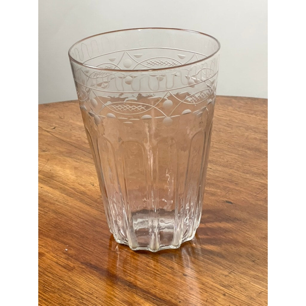 The Attributed Boston & Sandwich Wheel Engraved Mold-Blown Glass Table Vase, Circa 1845–1860—an elegantly clear piece featuring intricate wheel-engraved patterns—rests atop a wooden table against a simple, light-colored background.