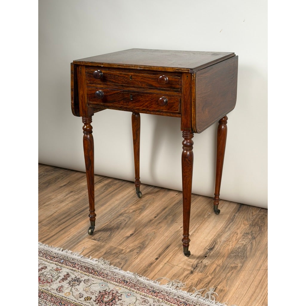 English Regency Rosewood Two-Drawer Drop-Leaf Work Table with Brass and Satinwood Inlay, circa 1820–1840, featuring turned legs on casters.