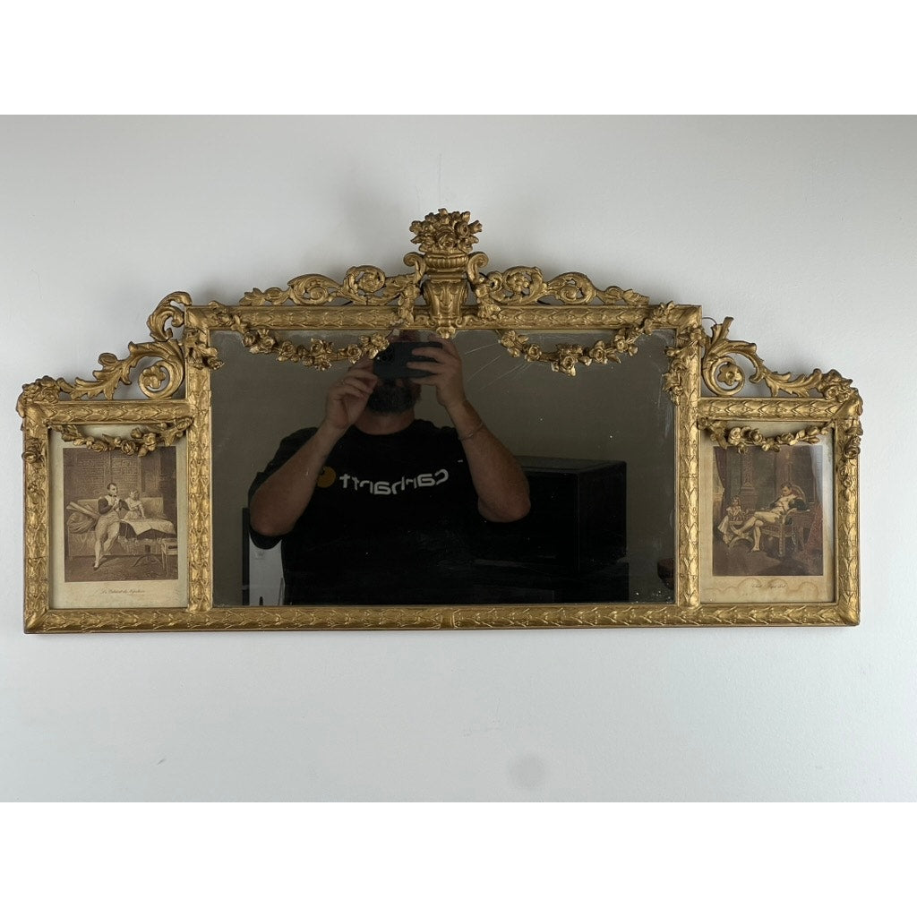 Exceptional Antique Louis XV Style Three Panel Mirror flanked by images of Napoleon, with gold detailing and intricate design, hangs on a plain white wall. A person in a black shirt holding a phone is reflected in the central panel.