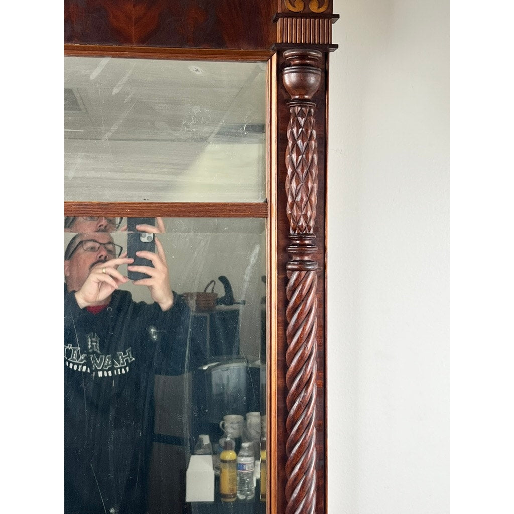 A person in glasses and a dark hoodie takes a mirror selfie in front of an Antique American Empire Mahogany Pier Mirror c. 1840; cleaning supplies and other items appear in the background. Brand: None/Unknown.
