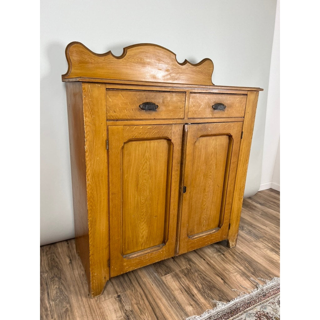 The Antique Victorian Grain Painted Country Jelly Cupboard c. 1870 features two drawers, paneled doors, a decorative back panel, and black metal handles—ideal vintage storage for a country kitchen on wood floors by light walls.