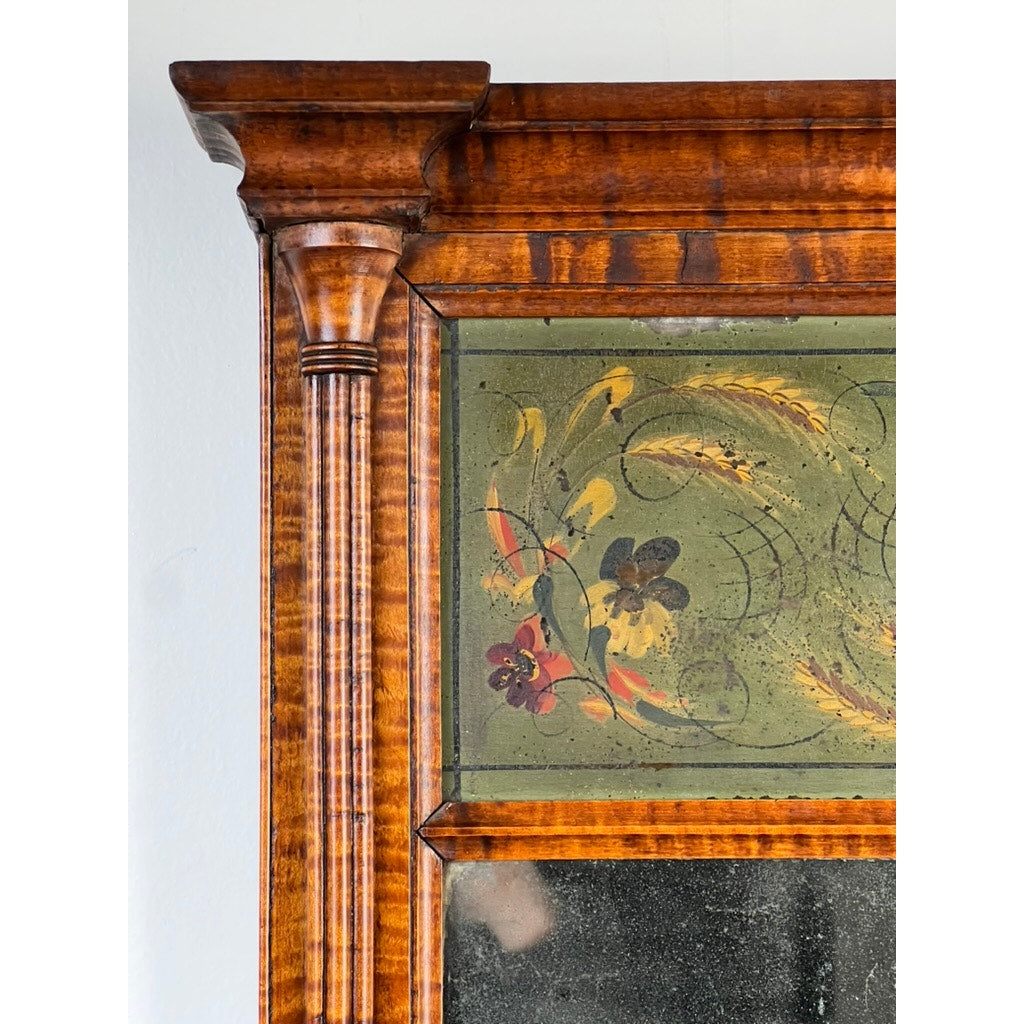 Close-up of the top left corner of a Fine Antique Federal Period Tiger Maple Two Panel Mirror c. 1820, showing ornate wood grain, molding, and a painted panel with yellow and red florals on green. Brand: Unknown.