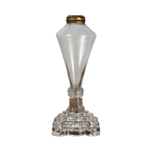 An attributed Boston & Sandwich pressed glass boudoir fluid lamp, circa 1850, crafted in clear glass with a brass top, featuring a geometric stepped base and a tall, tapered body—evoking the style of Victorian-era pressed glass lamps.