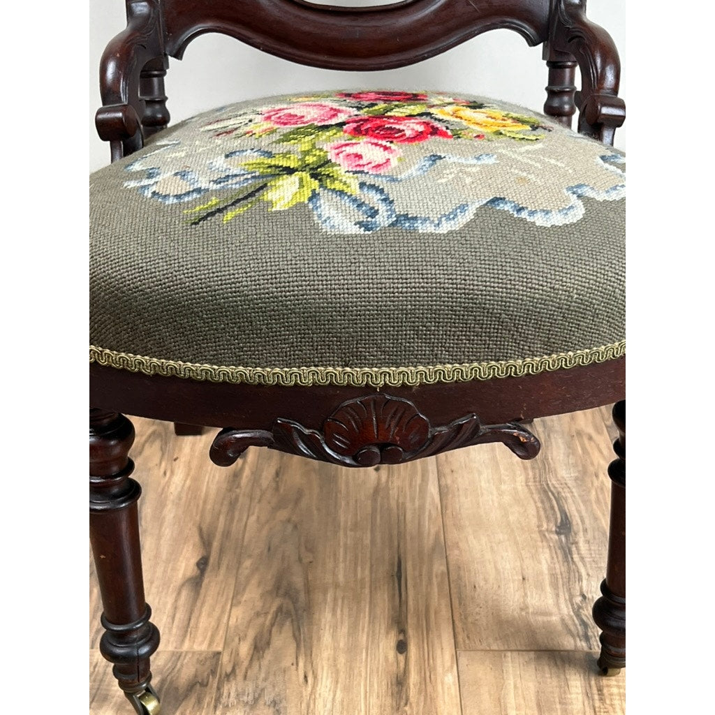 The Antique Victorian Rococo Revival Carved Walnut Slipper Chair c. Late 19th Century features ornate details and a floral needlepoint seat, exemplifying craftsmanship and elegance from the era. Brand is unknown.