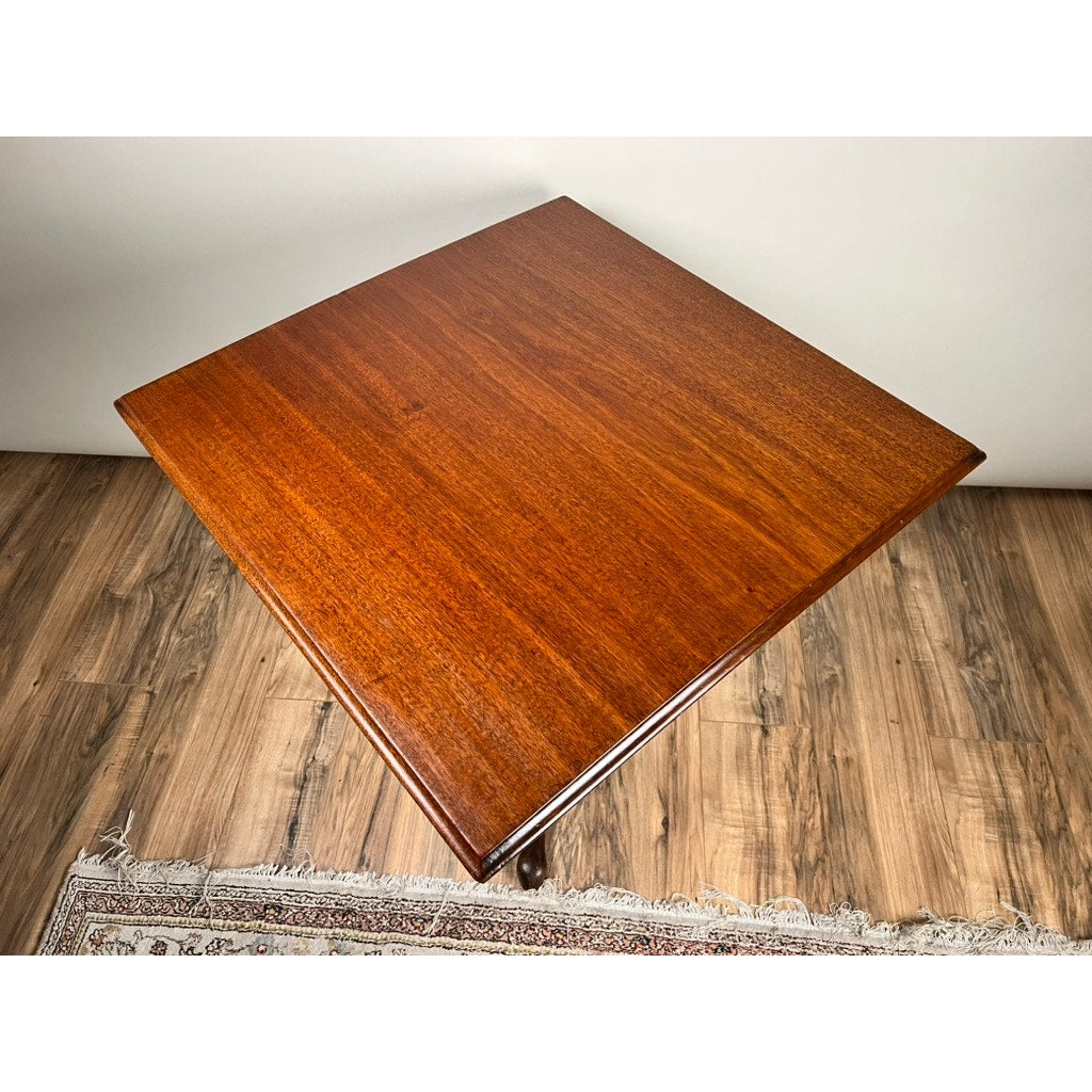 An Antique Queen Anne Mahogany Tilt Top Breakfast Table from the late 18th century sits on a wooden floor next to a patterned rug, its polished reddish-brown surface and rich wood grain highlighted in the overhead photo.