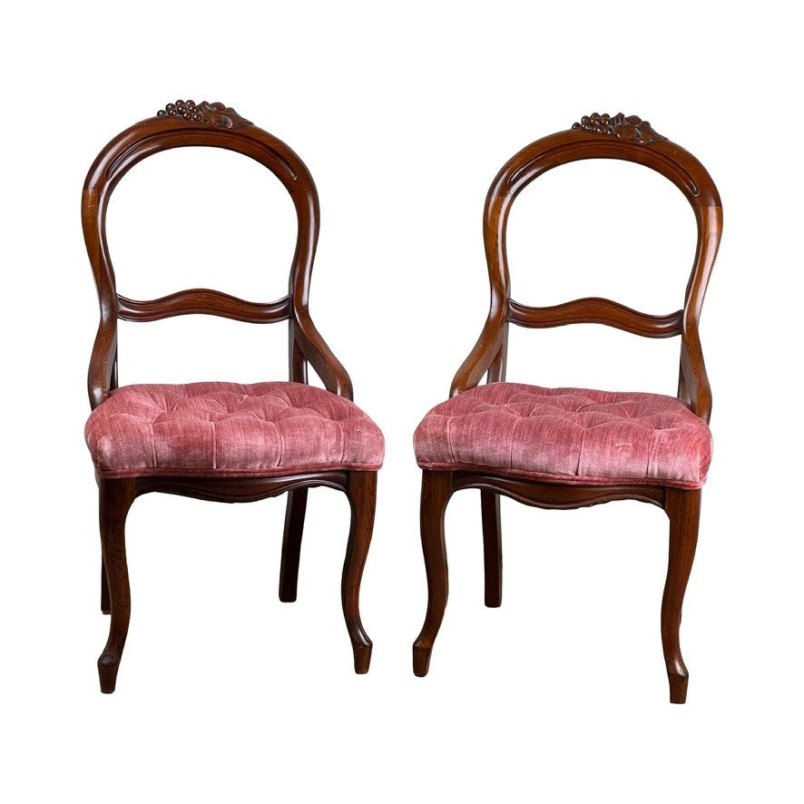 Antique Pair Victorian Walnut Balloon Back Tufted Side Chairs, late 19th century, with curved backs, carved details, pink tufted velvet seats, and dark polished walnut frames and legs. Brand: None/Unknown.
