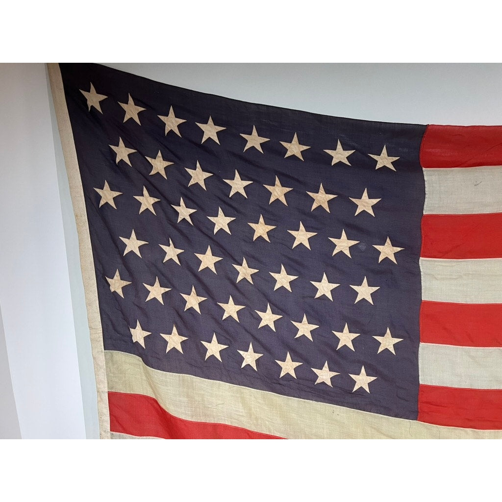 An Antique 45 Star American Flag from the Spanish–American War Era (9’9" x 6') hangs against a white wall. Brand: None/Unknown.
