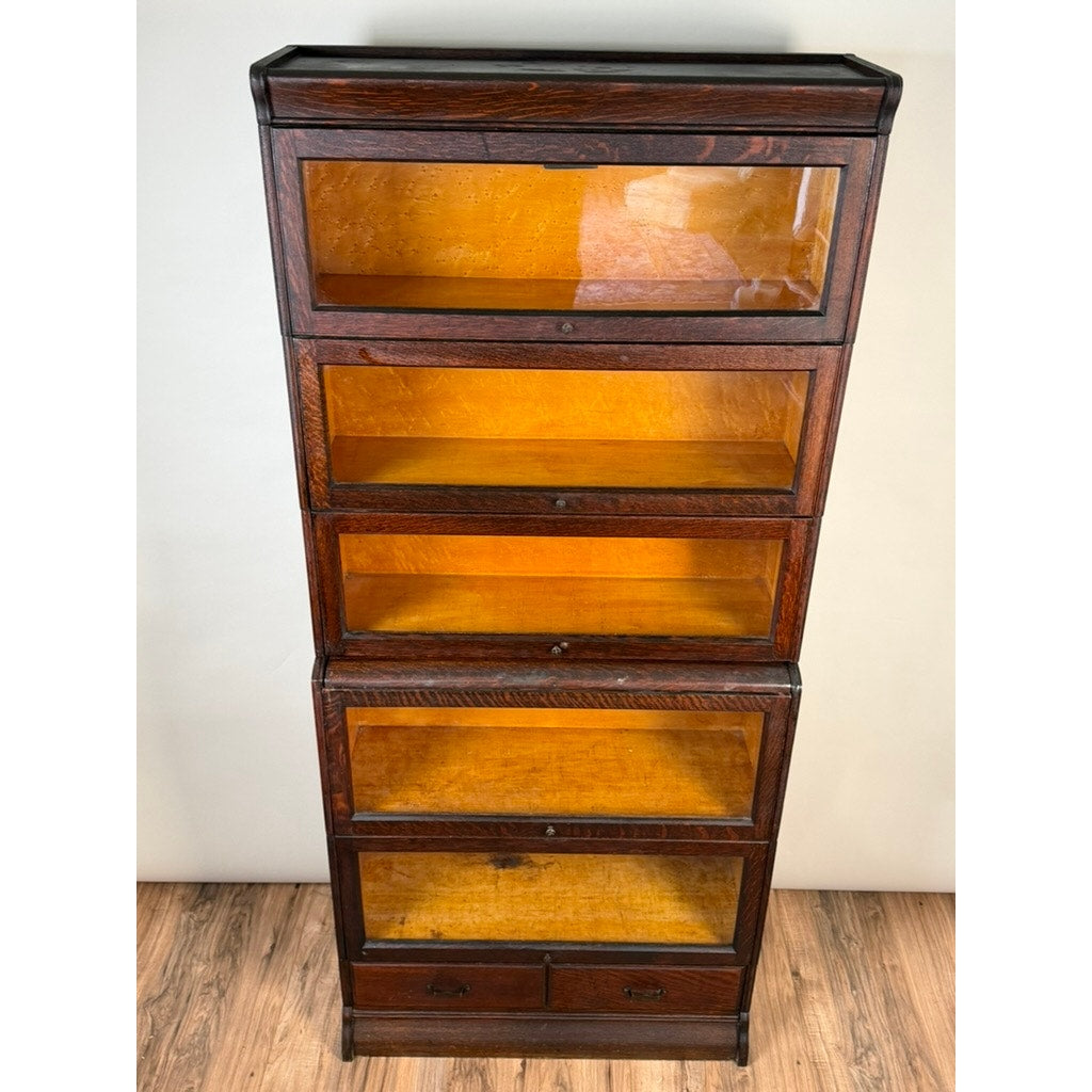 Antique Hale System Quarter-Sawn Oak Five-Stack Barrister Bookcase by Camden Cabinet Company, circa 1910, featuring five glass-fronted stacking sections and two small drawers at the bottom, standing on a wooden floor against a plain wall.