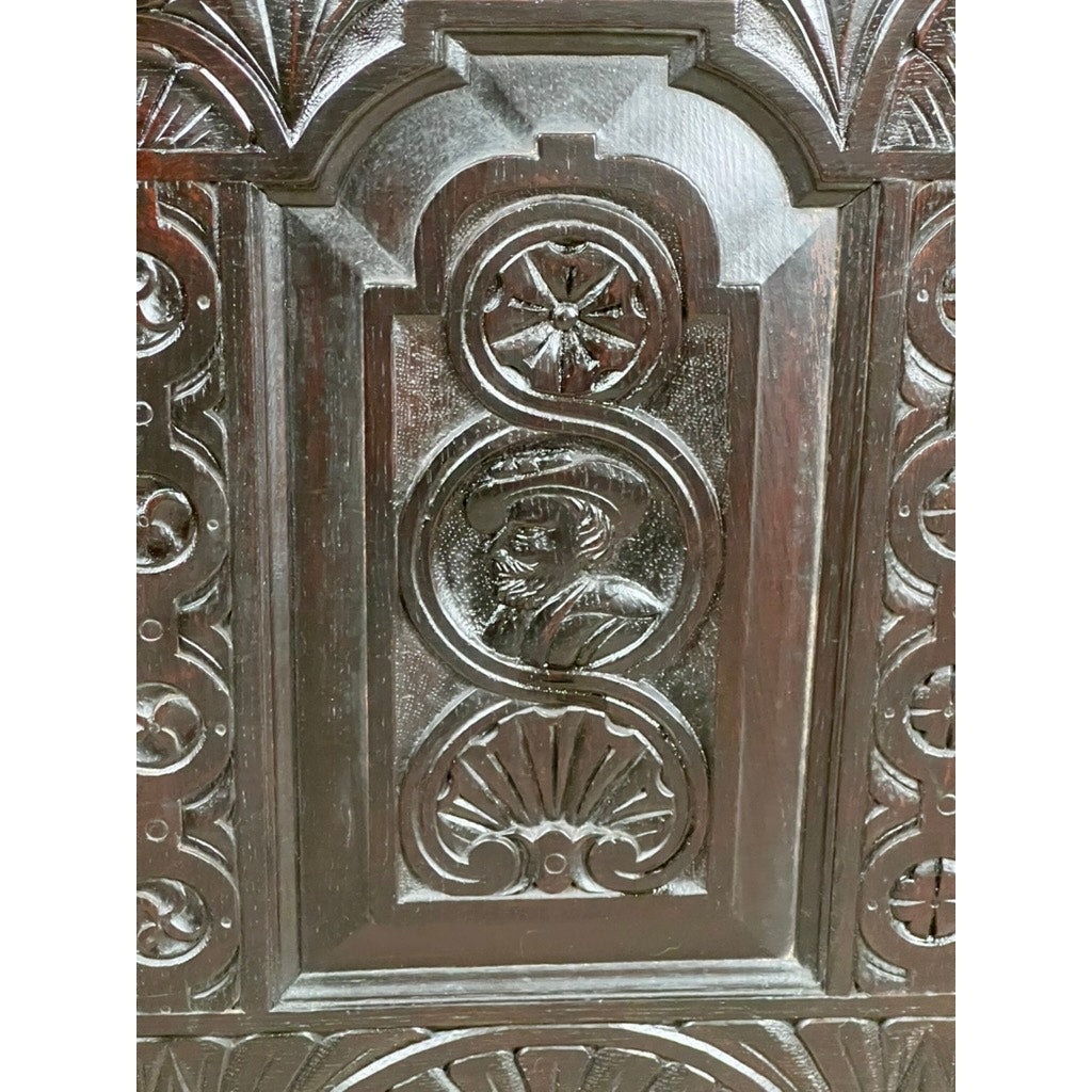 Antique 18th century Charles II style mule chest, possibly Irish or Scottish, featuring ornate carving with a central oval medallion of a bearded man in profile amid geometric and floral motifs—classic 17th-century-inspired detail. Brand unknown.