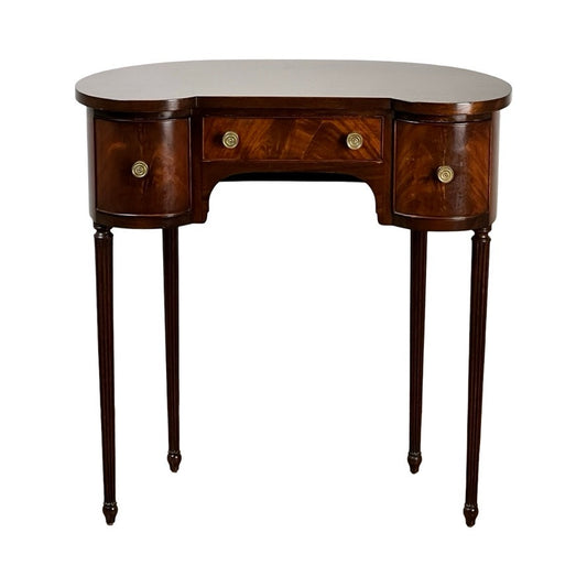 The Vintage Edwardian Sheraton Revival Kidney-form Dressing Table c. 1940 features mahogany veneers, three drawers with brass knobs, curved edges, slender tapered legs, and a rich polished brown finish. Brand: Unknown.