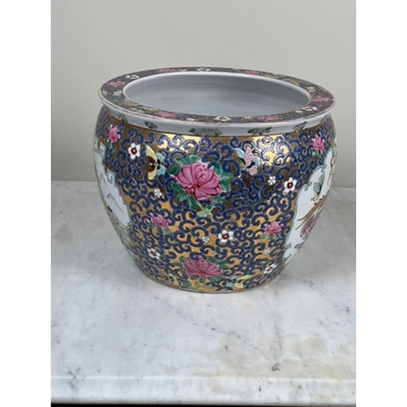 The Vintage Chinese Famille Rose Fish Bowl Signed Minicucci features blue and gold swirls, pink flowers, and white floral panels, displayed on a white marble surface as a striking statement planter.