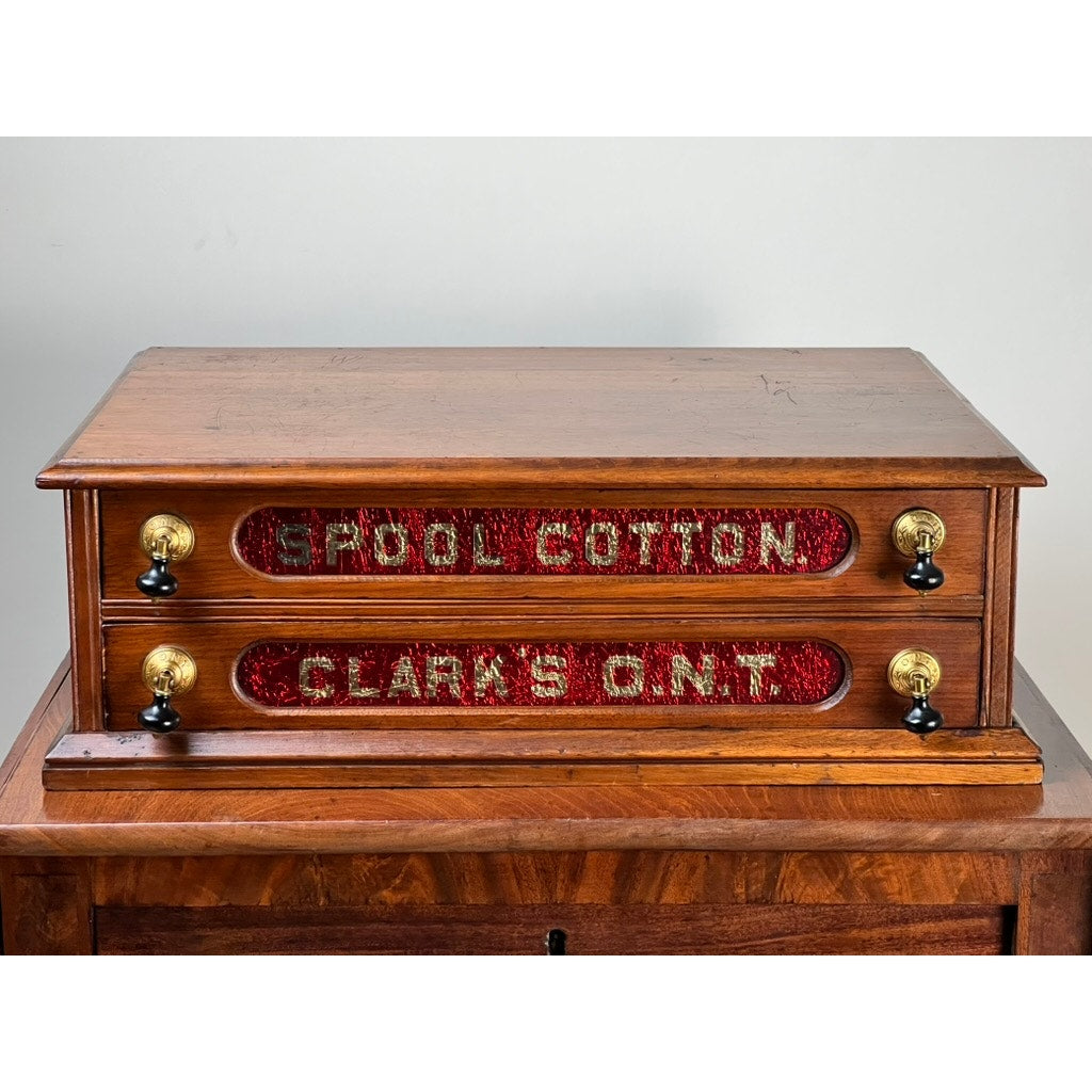 This Antique Victorian Pine Clark’s ONT Spool Cabinet, c. late 19th century, features two drawers labeled "SPOOL COTTON" and "CLARK'S O.N.T." in red and gold—an ideal collectible for sewing enthusiasts.