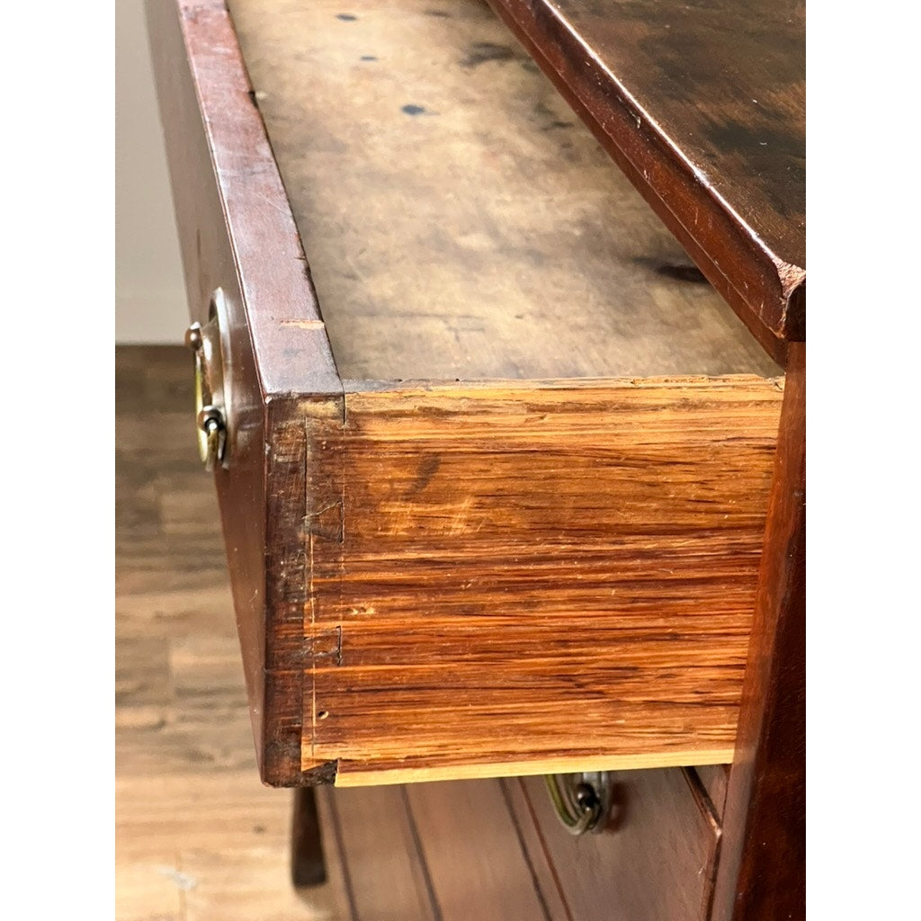 A close-up of a partially open drawer from a Rare Labeled William Lloyd Springfield Massachusetts Federal Cherry Chest of Drawers, Circa 1800, reveals the dovetail joint construction and brass drawer pull, along with some visible wear on the cherry wood—characteristic details of early American craftsmanship.