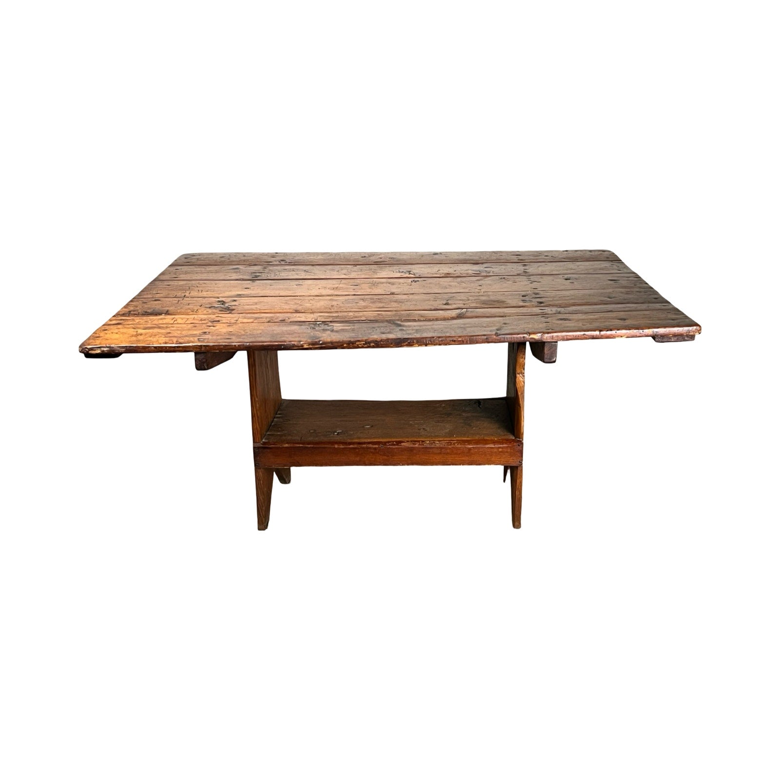 The Antique Country Pine Hutch Table with Six Plank Top c. 18th Century features a weathered rectangular surface, angled legs, and a lower shelf, inspired by classic country furniture and shown against a white background.