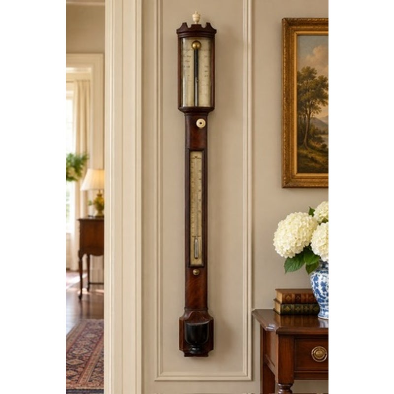An English Regency Mahogany Stick Barometer by Thomas Jones, Liverpool, c. 1820, mounted on a wall with an exposed thermometer and mercury gauge.