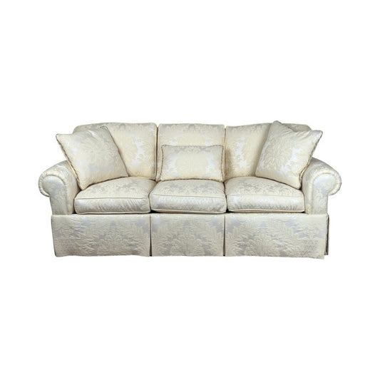 The Vintage Custom Ivory Upholstered Sofa by Stickley features three seat and back cushions, two armrest cushions, rounded arms, a skirted base, and elegant ivory damask upholstery with subtle floral patterns.