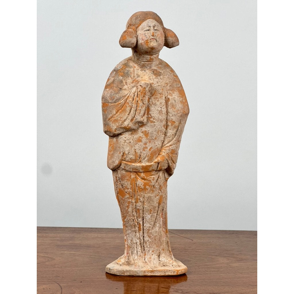 An Antique Chinese Tang Dynasty (618-907 AD) terracotta court lady figure with COA, depicted standing in traditional robes with clasped hands and stylized hair, is displayed on a wooden surface against a plain background.