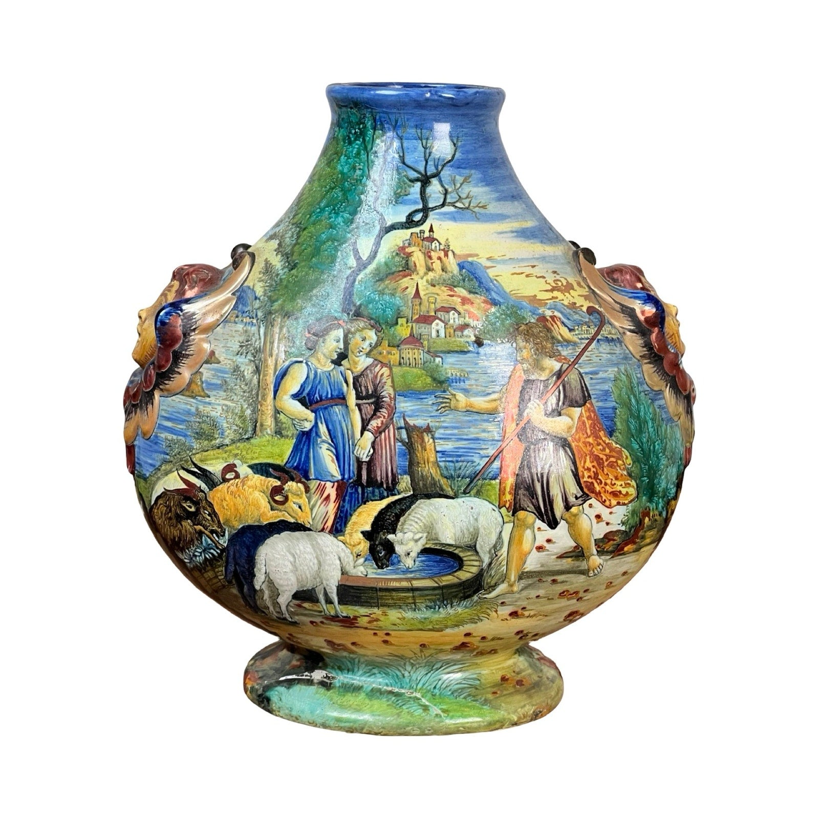 An Antique Italian Renaissance Revival hand-painted maiolica vase (c. 1920–1940) featuring painted pastoral scenes with people, sheep, and a dog, winged putti handles on the sides, and a castle on a hill in the background. Brand: Unknown.