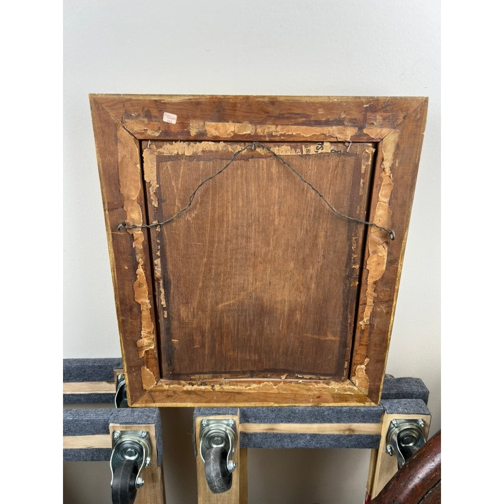 The image features an Antique Civil War Era Portrait of a Woman in a gilt wood frame, showing the back with aged wood, peeling paper edges, and hanging wire. The framed artwork rests on a cart with wheels against a plain light wall. Brand: Unknown.