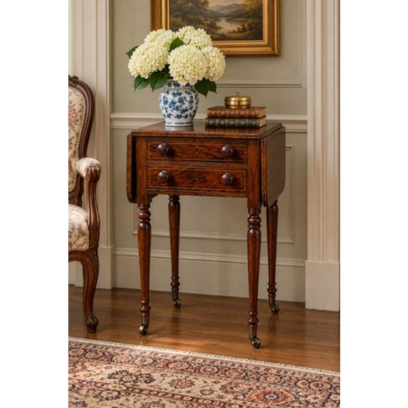 English Regency Rosewood Two-Drawer Drop-Leaf Work Table with Brass and Satinwood Inlay, circa 1820–1840, featuring turned legs and brass casters, topped with a vase of white hydrangeas and books.