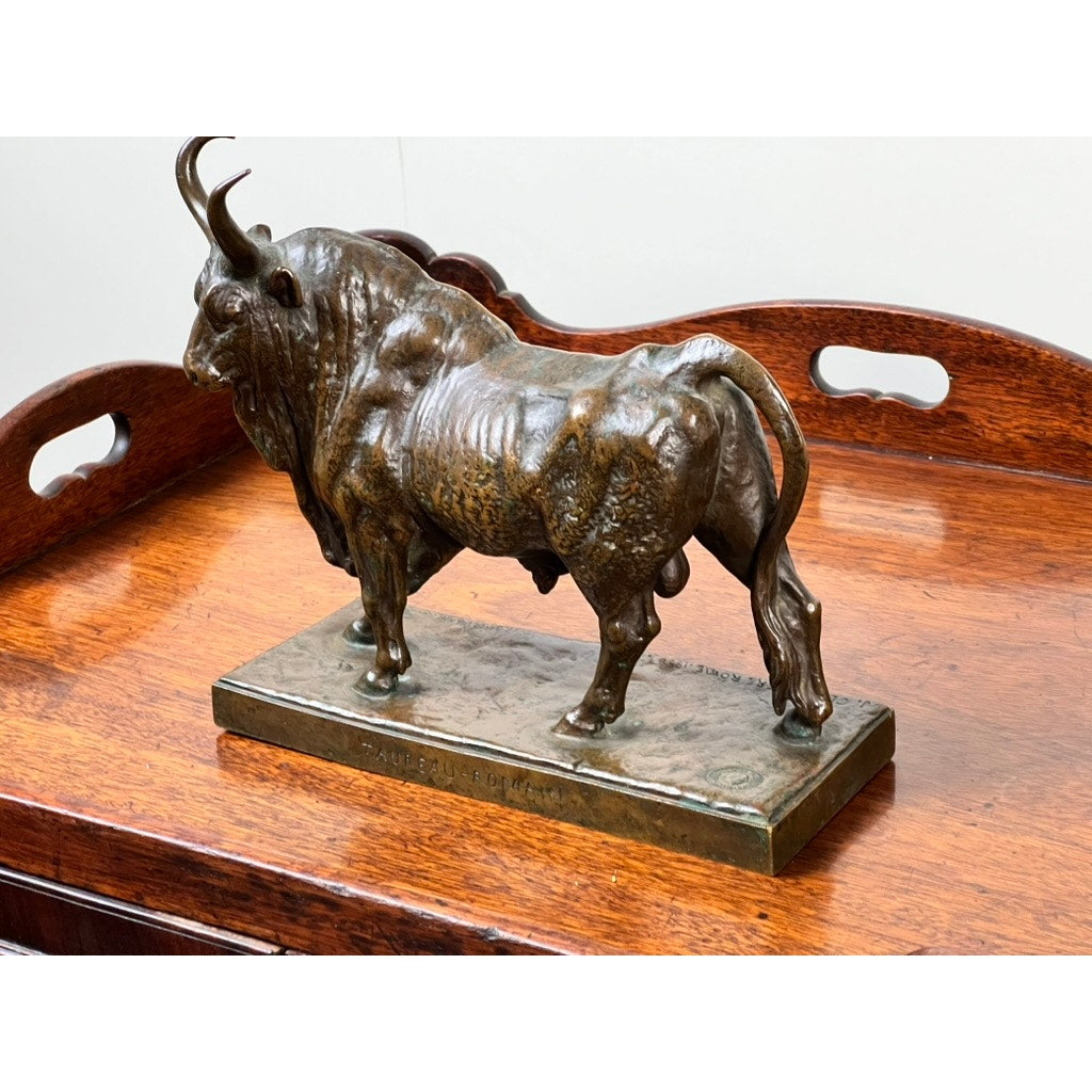 The “Taureau Romain” bronze sculpture by Jean-Baptiste Clesinger, cast by Barbedienne in Rome in 1858, features detailed musculature and curved horns on a rectangular base atop a polished wooden tray with handles.