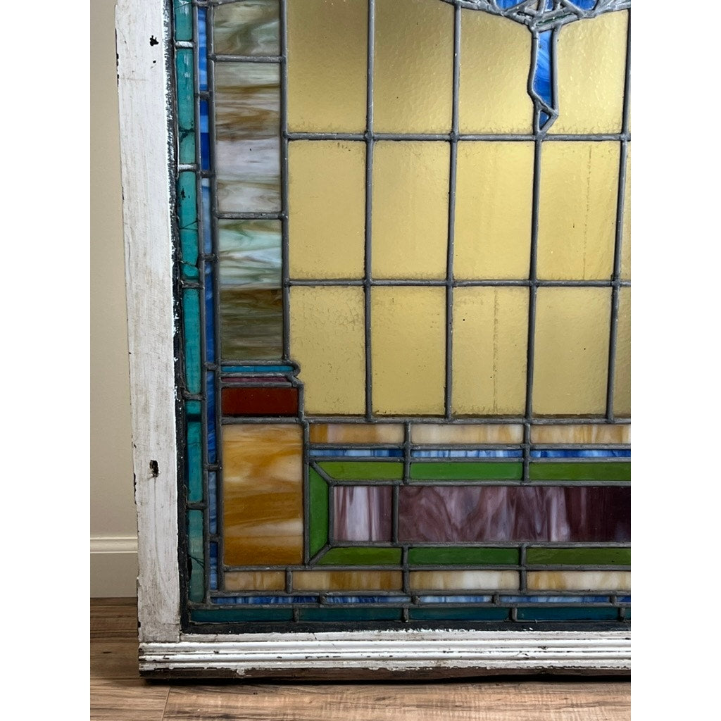 Antique stained glass with arched design and colorful geometric borders
