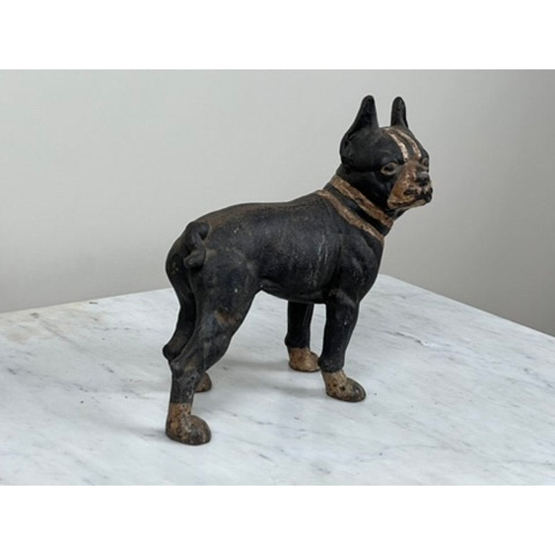 A Hubley Antique Cast Iron Boston Terrier Doorstop with pointed ears and a short tail stands on white marble against a light gray background.